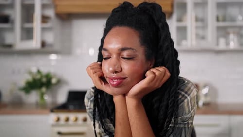Young Woman Smiles at Kitchen Counter with Food
