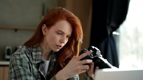 Woman Reviews Photos on Camera Indoors