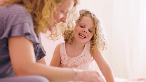 Woman and Child with Curly Hair Smiling Indoors