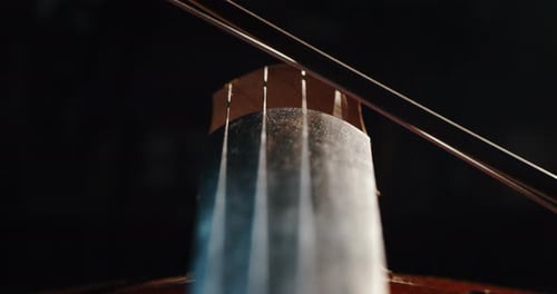 Slow motion artistic macro of master artisan luthier playing with a bow on a handmade violin or ce