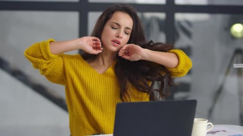 Brunette Woman Stretching While Working on Laptop