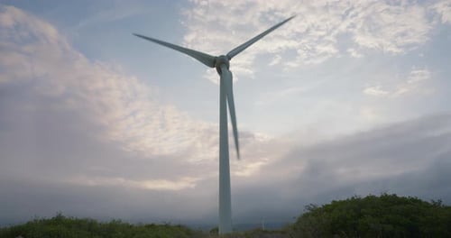 Windturbine dreht sich am Himmel bei Sonnenuntergang und erzeugt grüne Energie