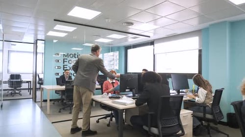 Gerente entregando arquivos aos funcionários no espaço de trabalho de coworking