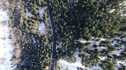 Top view on the mountains hill with the long road and forest in snow, 4k