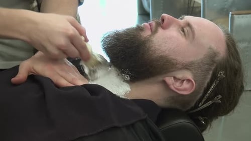 Barber Applying Shaving Cream to Bearded Man