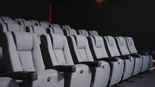 Dramatic Lit Modern Cinema Seating With Armrest In Dark Movie Theatre, 4K