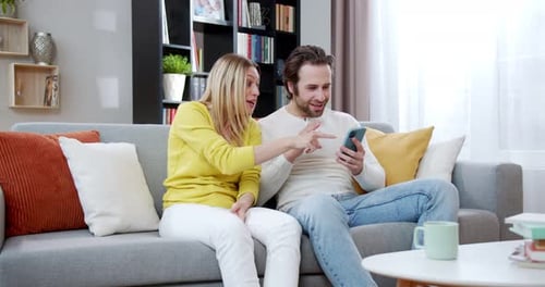 Happy Couple Celebrates Success on a Smartphone