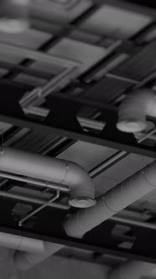 Sistemas eléctricos y de ventilación, conexiones con cables y tuberías metálicas dentro de un edificio moderno