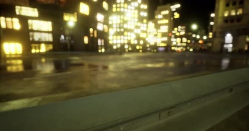 City at Night with Illuminated Buildings Reflecting on Wet Pavement