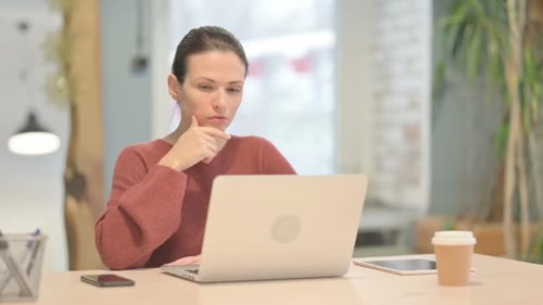 Woman Thinking While Working on Laptop