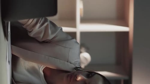 Stressed Woman Covers Face at Desk