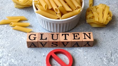 Italienische ungekochte trockene Penne-Regatta-Nudeln mit einem Glutenverbotsschild. Das Glutenverbotszeichen