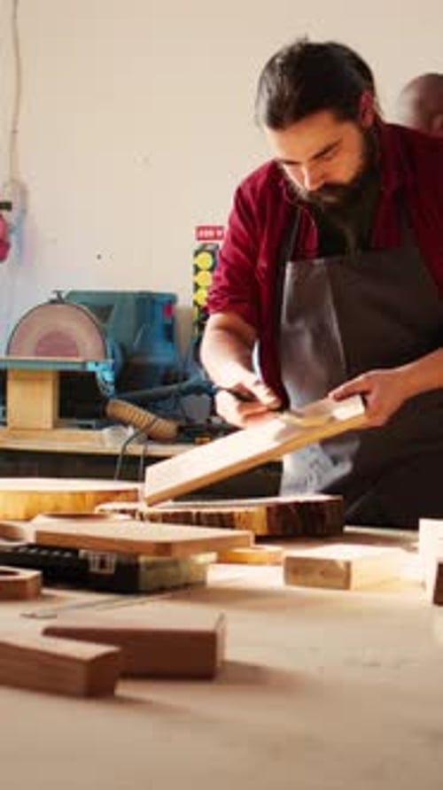 Vidéo verticale : un menuisier dans un atelier d'assemblage entame un projet de rénovation sur une planche de bois