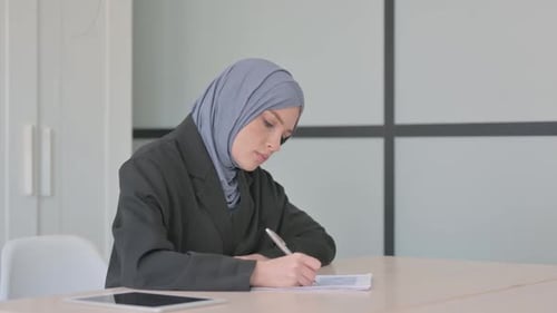 Muslim Businesswoman Doing Paperwork in Office