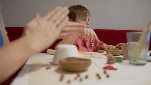 Boy with Mother during Remote Clay Workshop at home. Learning from the online courses, working with