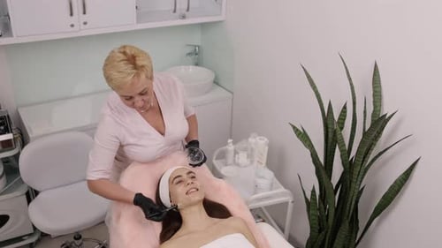 Beautician Applying Facial Mask in Modern Beauty Clinic