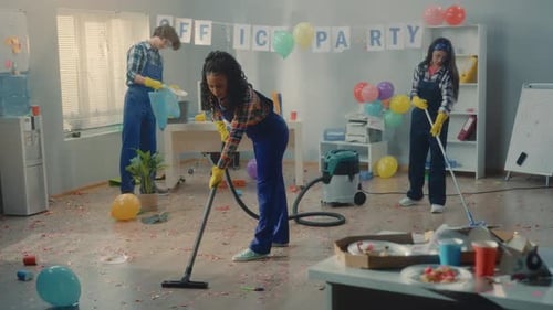 Um grupo multinacional de faxineiros limpa o escritório depois de uma festa Uma mulher afro-americana e