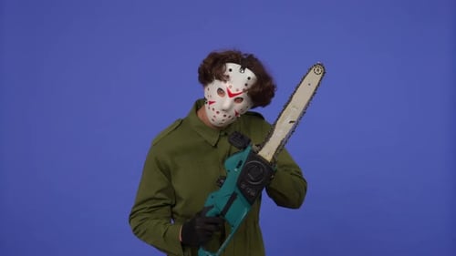 Man in White Mask with Chainsaw in Hands on Blue Background Image of Maniac Jason Voorhees From