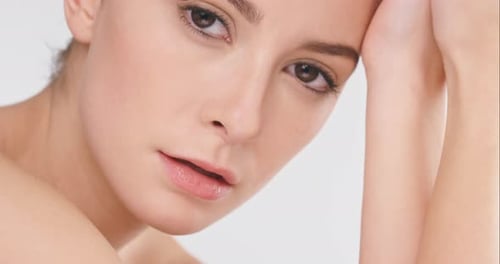 4k video footage of a young woman posing against a studio background