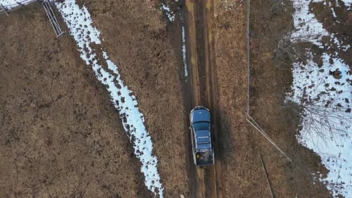 Aerial View of Pickup Truck on Muddy Rural Road Topdown Drone View of a Pickup Truck Driving Along a