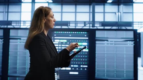 Technician Doing Yearly Checkup Using Tablet to Preserve Data Center Electronics