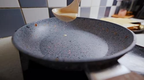 Pancake Batter Poured Into Nonstick Skillet in Kitchen
