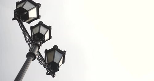 Ornate Black Street Lamps Against Bright Sky