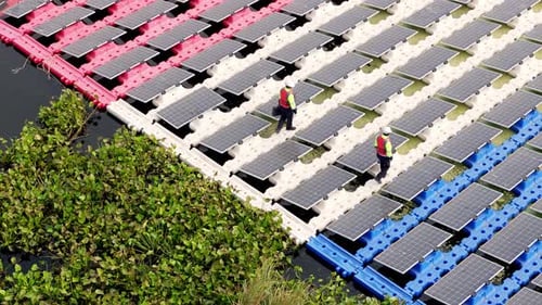 Schwimmendes Solarpanel auf dem Teich. Der Arbeiter wartet und überprüft schwimmende Photovoltaikmodule.