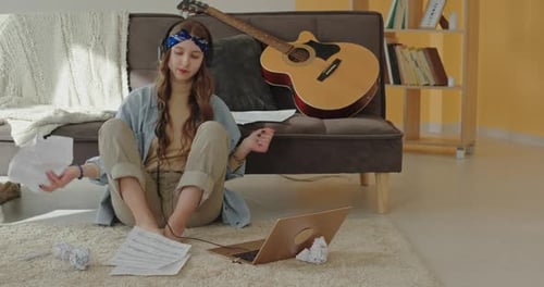 Frustrated Songwriter Tearing Paper Near Guitar at Home
