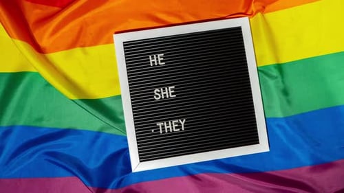 Stop Motion of HE SHE THEY Text Neo Pronouns Concept on Rainbow Flag Background Gender Pronouns