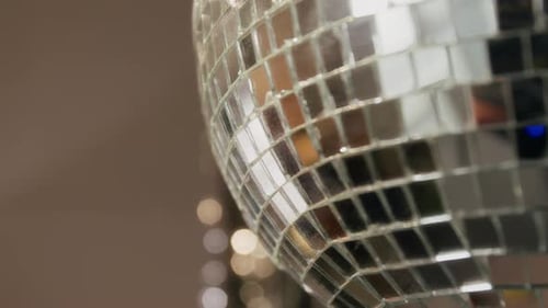 Close-up of Disco Ball with Mosaic Mirror Tiles Rotating in Room