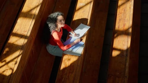 Vue de dessus Une étudiante écrivant un auditorium universitaire regardant la caméra, une femme latina hispanique souriante