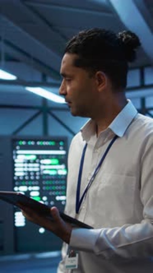 Vertical Video Engineer Walking in Data Center Monitoring Security Threats