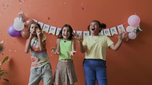 Two Girls and Boy Enjoying Colourful Confetti at Birthday Party