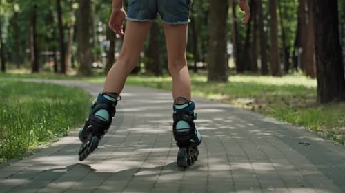 Low section of girl skating at the park in summer day. Shot with RED helium camera in 8K.