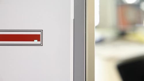 Close-up of a 'Please Wait' message on a screen with blurred office background