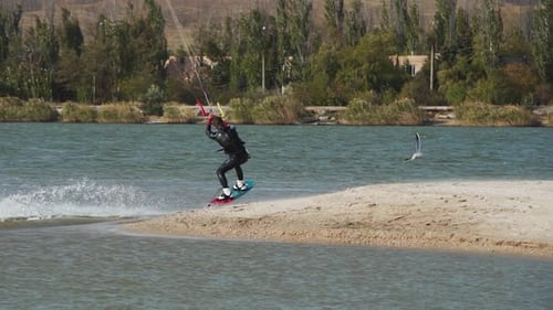 Un kitesurfeur fait des balades sur un cerf-volant à Sea Bay Entraînement acrobatique de cerf-volant sur un étang