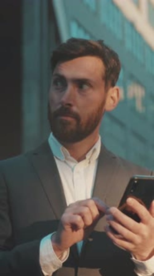 Man in Suit Using Phone in City Environment