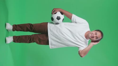 Full Body Of Asian Man With A Ball Cupping Ear To Listen While Cheering Soccer On Green Screen