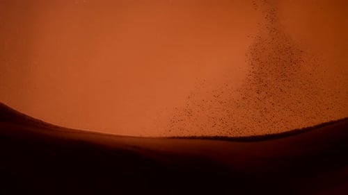 Dust particles falling onto a pile of sand in abstract slow motion