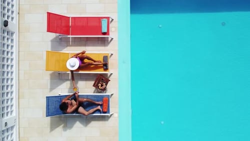 Couple Toasting on Sun Loungers by the Pool, Vacations