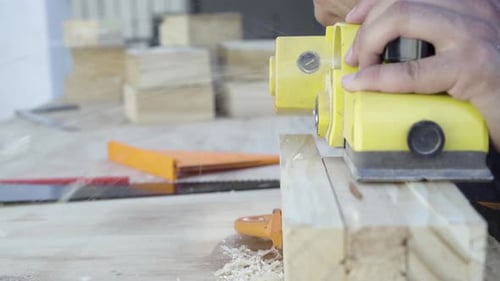 Close up shot of electric planer power tool planing wood by a craftsman tradesman