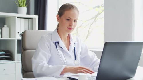 Doctor Works in the Medical Office Woman in White Coat Workplace of a Professional Female Therapist