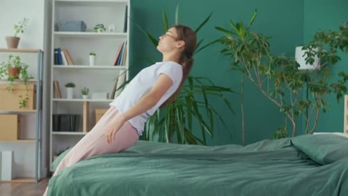 Woman Reclines Comfortably on Green Bed at Home