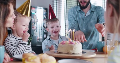 Family Celebrates Child's Birthday with Cake at Home
