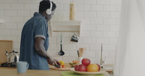Adult Chopping Vegetables at Home in Sunny Kitchen