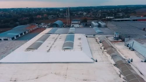 Plain roofs of the industrial warehouses with windows.