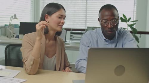 Multiethnic Colleagues Discussing Project on Laptop in Office
