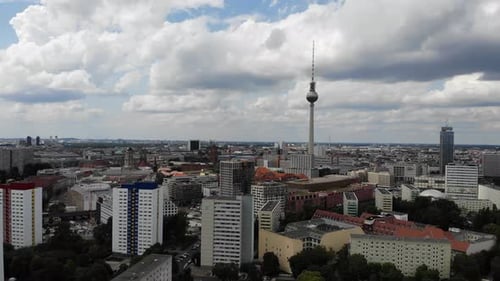 4k drone backward movement berlin tv tower with clouds and blue sky and high rise buildings friedric