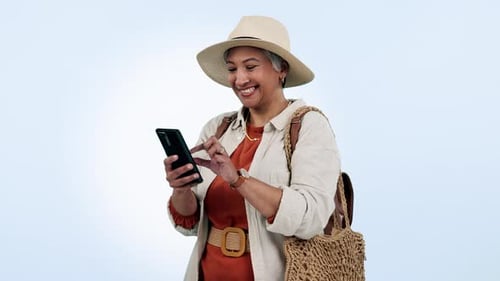 Phone, smile and senior woman in a studio networking on social media, mobile app or internet